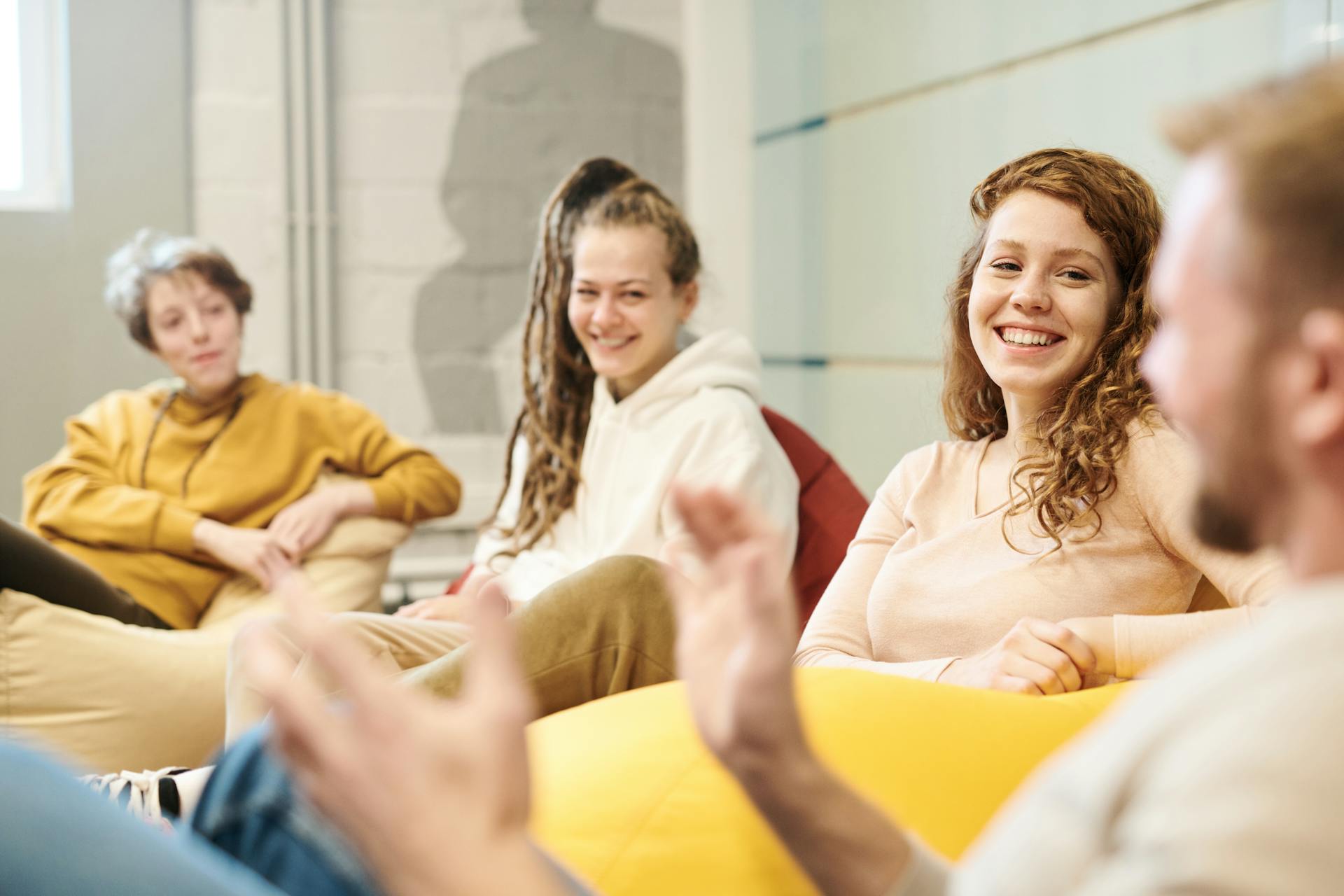 Colleagues talking and laughing while sitting on bean bags.